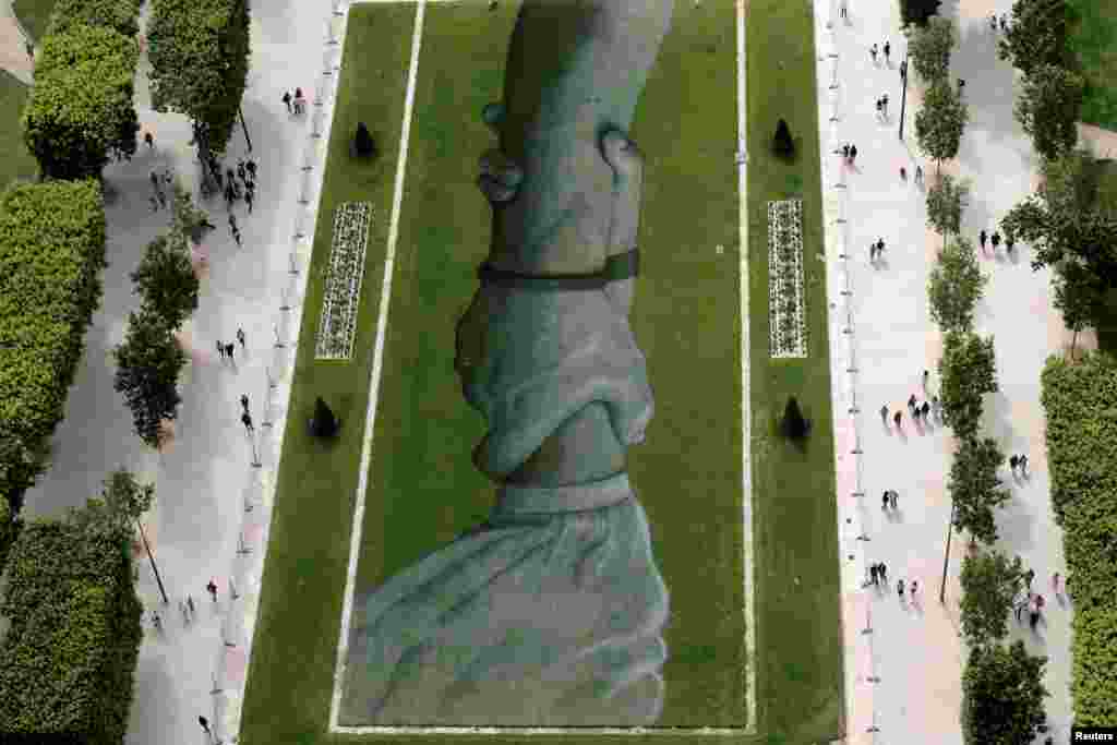 A view shows a section of the giant artwork 'Beyond Walls' by French street artist Saype, a spray-paint series of interlocked hands across the lawns of the Champs de Mars in Paris, France.