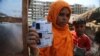 A Rohingya woman displays family members' identity cards issued by United Nations High Commissioner for Refugees (UNHCR) at their makeshift camp on the outskirts of Jammu, India, March 9,2021.
