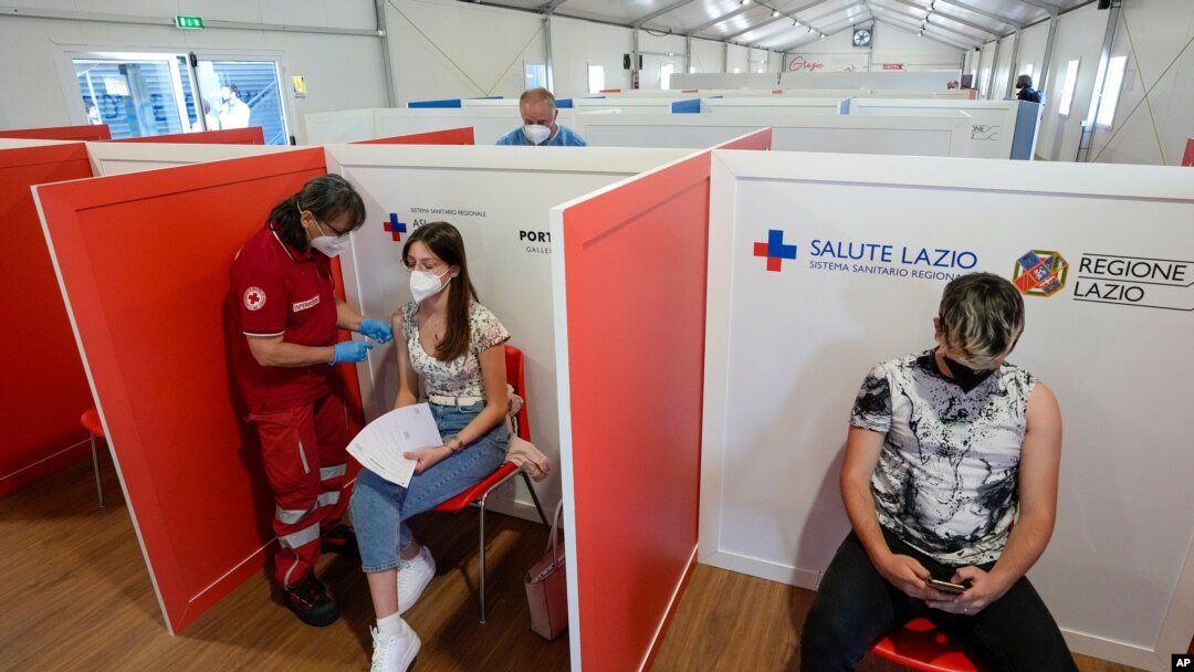 FILE - A young woman is administered her first dose of a COVID-19 vaccine, at a vaccination site set up in a shopping mall on the outskirts of Rome, Italy, June 1, 2021. 