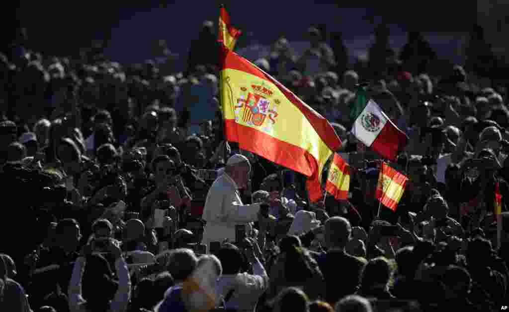 Pope Francis passes by a Spanish flags waving in the crowd during his weekly general audience, in St. Peter's Square, at the Vatican.