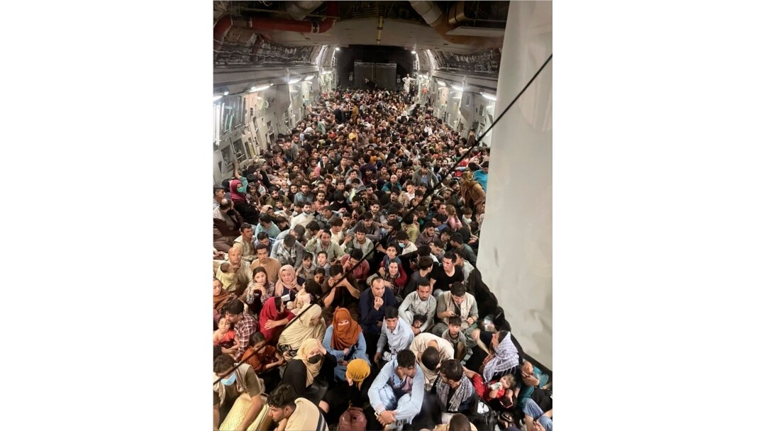 Afghan citizens pack inside a U.S. Air Force C-17 Globemaster III, as they are transported from Hamid Karzai International Airport in Afghanistan, Sunday, Aug. 15, 2021. The Taliban on Sunday swept into Kabul, the Afghan capital, after capturing most of