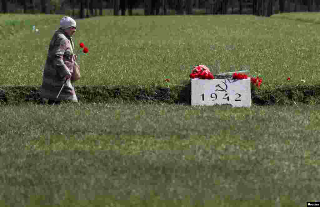 A woman carries flowers at the Piskaryovskoye Memorial Cemetery on the eve of the Victory Day, marking the 74th anniversary of the victory over Nazi Germany in World War II, in Saint Petersburg, Russia.