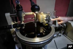 Sound operator William Carvalho begins cutting a record on an acetate surface that is part of the first stage of vinyl production at the Polysom factory in Belford Roxo, Brazil, Tuesday, April 16, 2024. (AP Photo/Bruna Prado)