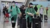 身穿防護服和戴口罩的旅客抵達香港國際機場。 （2020年3月23日）