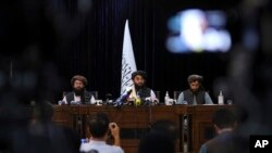 El portavoz de los talibanes, Zabihullah Mujahid, en el centro, habla en su primera conferencia de prensa, en Kabul, Afganistán, el martes 17 de agosto de 2021.