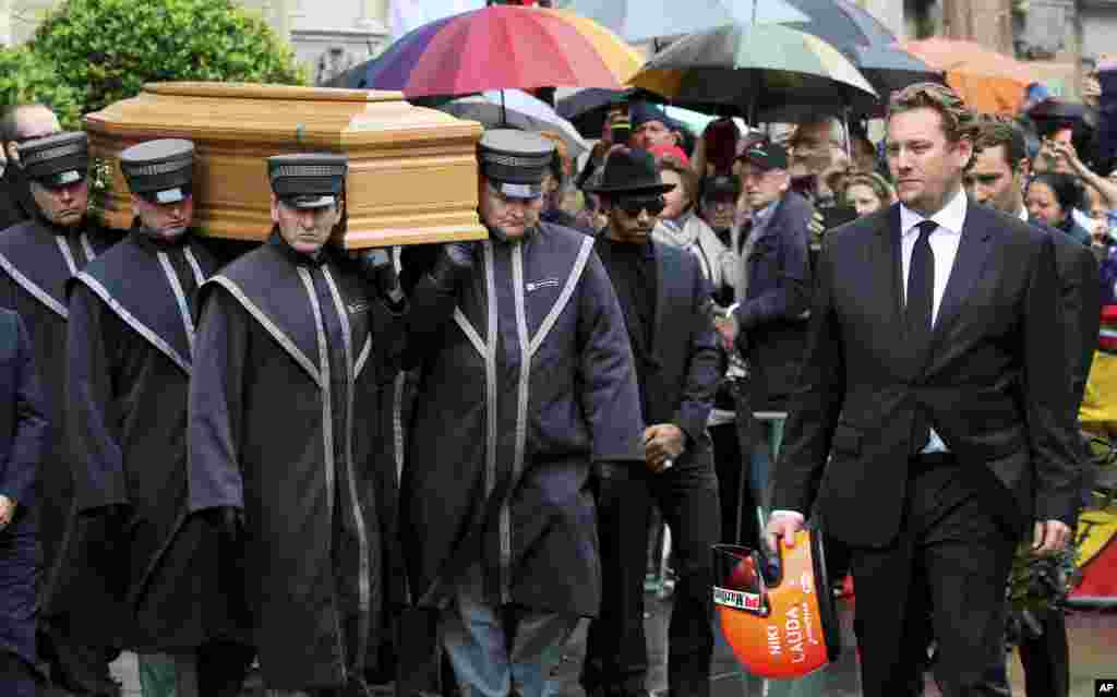 Lukas, right, holds his father's helmet as he walks in front of the coffin of former Formula One driver Niki Lauda after a funeral service in Vienna, Austria. Three-time Formula One world champion Niki Lauda, who won two of his titles after a horrific crash that left him with serious burns and went on to become a prominent figure in the aviation industry, died aged 70.