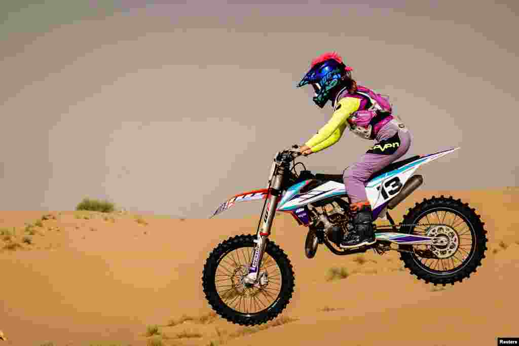 Hayley O'Connor, 14, rides her dirt bike during the summer heat in the desert of Dubai, United Arab Emirates.
