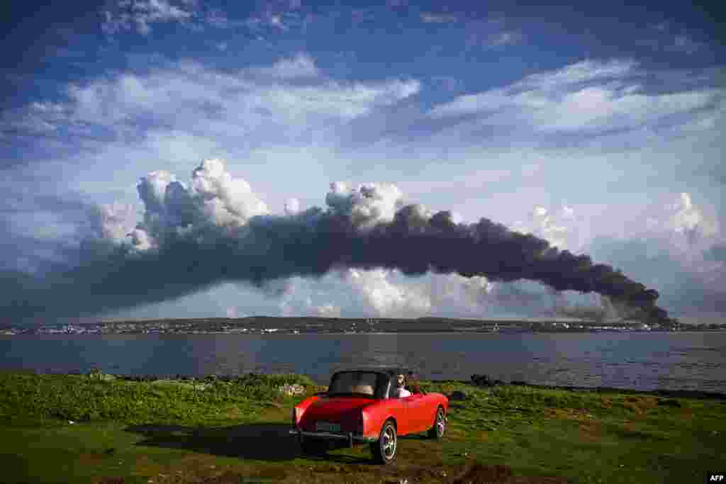 Black smoke from oil tanks on fire is seen near the Matanzas bay, Cuba. Planes carrying products, firefighters and specialists from Mexico and Venezuela arrived in Cuba to help put out the fire of two oil tanks, which enters its third day with one dead, 17 missing and 36 hospitalized.