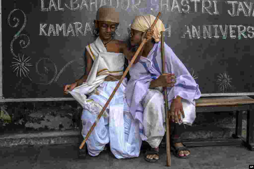 School children dressed as iconic independence leader Mahatma Gandhi sit on a bench after taking part in an event to mark his birth anniversary in Mumbai, India.