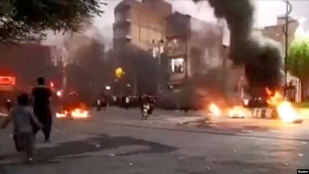 A person rides a motorcycle near a fire during a protest over the death of Mahsa Amini, in Javanrud, Iran, in this screengrab from a social media video released on Oct. 8, 2022, obtained by Reuters on Oct. 9, 2022.