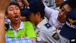 一名南韓進步黨成員(左)在首爾南部的水原市遭南韓情報局逮捕。