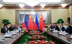 FILE - Philippine President Rodrigo Duterte, left, and Chinese President Xi Jinping, right, meet at the Diaoyutai State Guesthouse in Beijing, China, Aug. 29, 2019.