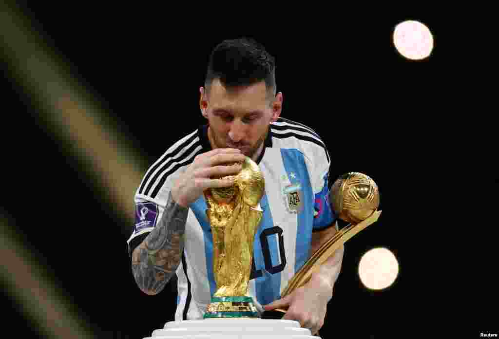 Argentina's Lionel Messi kisses the World Cup trophy after receiving the Golden Ball award as he celebrates after winning the World Cup soccer match between Argentina and France at the Lusail Stadium in Lusail, Qatar, Dec. 18. 2022.