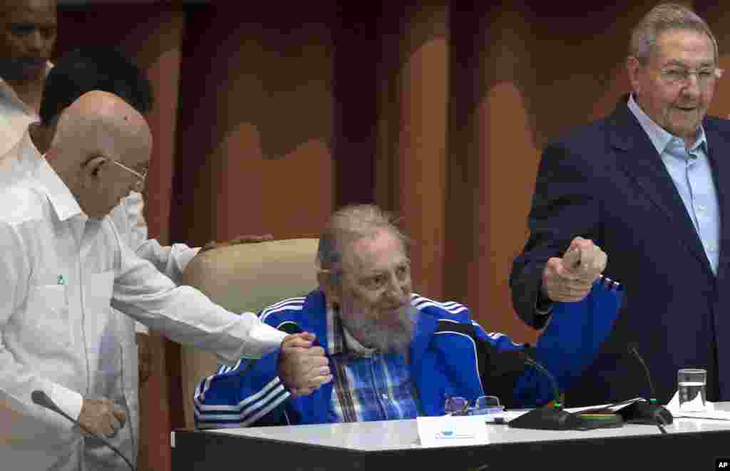 Líder cubano Fidel Castro apertando a mão do irmão, presidente Raul Castro (dir) e do segundo secretário do Comité Central, Jose Ramon Ventura, momentos antes de ser tocado o hino do partido Comunista durante cerimonias de encerramento do VII Congresso do Partido Comunista Cubano, em Havana, Cuba (19 Abril 2016). 