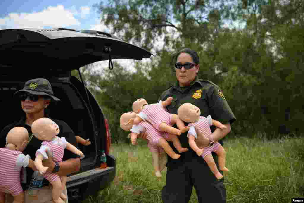 U.S. Border Patrol agents hold infant dolls in preparation for a demonstration during a 'Border Safety Initiative' media event at the U.S.-Mexico border in Mission, Texas, July 1, 2019.