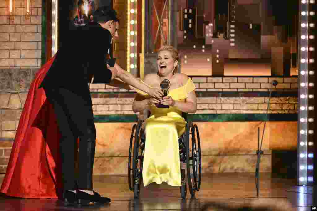 Laura Benanti, from left, and Anthony Ramos present the best performance award to Ali Stroker for her performance in "Rodgers & Hammerstein's Oklahoma!" at the 73rd annual Tony Awards at Radio City Music Hall, June 9, 2019, in New York.