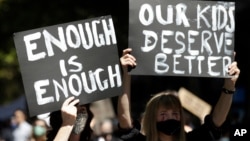 FILE - Thousands of people with placards and banners rally demanding justice for women in Sydney, Monday, March 15, 2021, as the government reeled from two separate allegations. The rally was one of several across Australia.