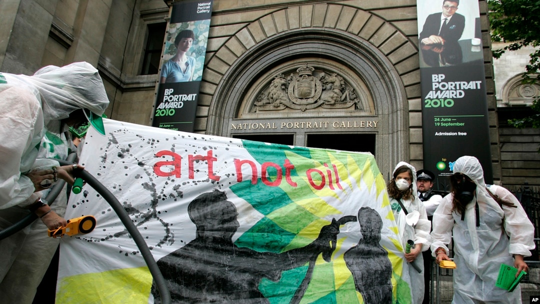 Campaigners dressed as a mock clean-up crew called the 'Greenwash Guerrillas' hold a banner outside the National Portrait Gallery in London, Tuesday, June 22, 2010, where the BP Portrait Award ceremony is held.