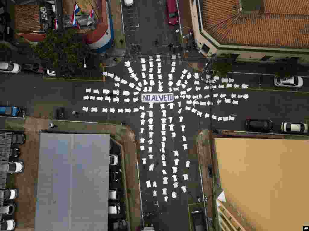 The white coats of doctors lie on the street around the Spanish message "No to the veto," directed at President Mario Abdo Benítez, asking him to not veto a proposed law that would allow doctors, from both the public and private sectors, to partially retire after 25 years of work, in Asuncion, Paraguay, May 20, 2019.