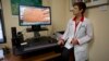 FILE - University of Miami dermatologist Dr. Anne Burdick checks the computer screen in her Miami office as she discusses telemedicine, April 8, 2014.