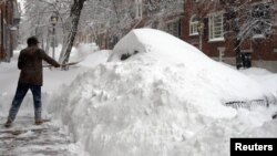 這名波士頓居民星期六在自己房屋前的人行道上鏟雪