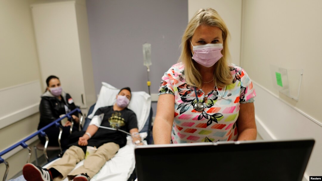 FILE - Emergency room nurse Christine Bauer treats Joshua Lagade of Vista, California, for the flu in the emergency room at Palomar Medical Center in Escondido, California, U.S., Jan.18, 2018. 