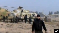 In this image taken from video obtained from the Ugarit News, which has been authenticated based on its contents and other AP reporting, Syrian rebels capture a helicopter air base near the capital Damascus after fierce fighting in Syria, on Sunday, Nov.