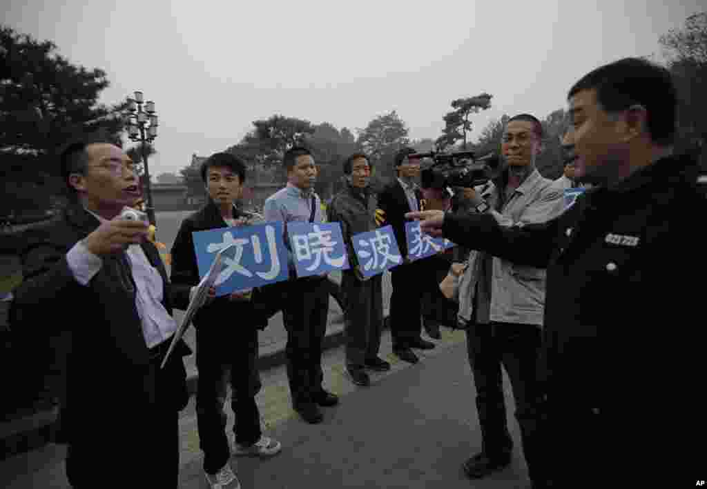 劉曉波的支持者在北京一個公園外面展示標語“慶祝劉曉波獲諾獎”,警察和他們談話(2010年10月8日)