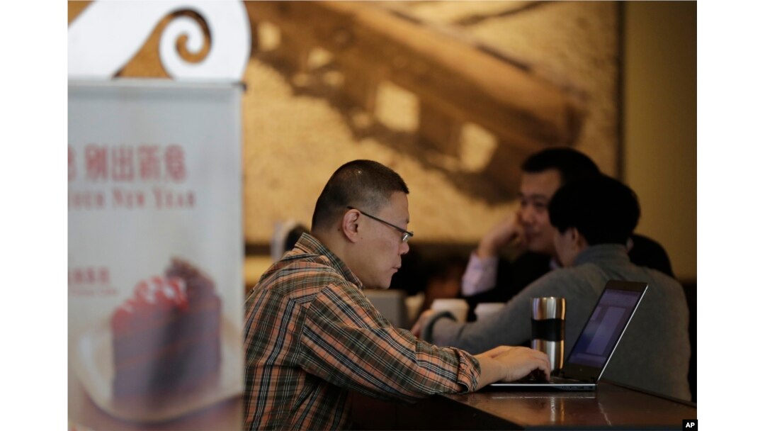 FILE - A man surfs Internet on his laptop computer at a Starbucks cafe in Beijing, Feb. 16, 2015.