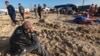 Displaced Palestinians check their belongings in a tiny coastal area of a territory named Al-Mawasi after Israeli tanks reportedly raided the sector, west of Khan Yunis, in the southern Gaza Strip on Feb. 21, 2024, amid the ongoing war between Israel 