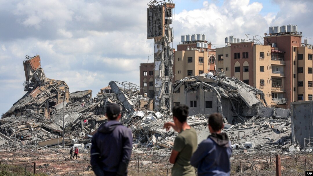 Mladići u Gazi posmatraju ruševine u mestu Asra (Foto: AFP)