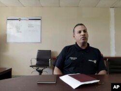 In this Jan. 9, 2018 photo, inspector Elexis Torres, is interviewed in Carolina, Puerto Rico. Torres heads a unit that is investigating eight homicides in a jurisdiction that includes the working-class city.