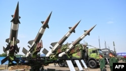 Vietnamese military officials look at S-125-2TM anti-aircraft missile launchers and ammunition during the Vietnam 2024 International Defense Expo in Hanoi on Dec. 19, 2024.