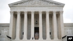 In this Oct. 9, 2018 photo, police office guards the main entrance to the Supreme Court. The court is taking up its first gun rights case in nine years, a challenge to New York City's prohibition on carrying a licensed, locked and unloaded handgun outside the city limits.