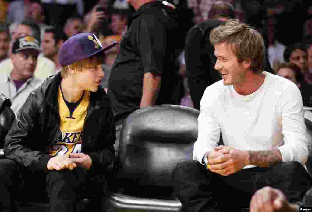 Justin Bieber chats with David Beckham during the NBA game between the Los Angeles Lakers and the Houston Rockets in Los Angeles, California, October 26, 2010.