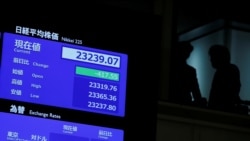 Los asistentes se ven junto a una pantalla que muestra el índice de precios de las acciones después de la ceremonia de apertura de Año Nuevo en la Bolsa de Valores de Tokio (TSE), celebrada para desear el éxito del mercado de valores de Japón en Tokio, Japón, el 6 de enero de 2020. REUTERS / Kim Kyung -Hoon