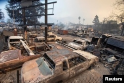 Burned vehicles are seen as the wildfires burn in the Los Angeles area, at the Eaton Fire in Altadena, California, Jan. 9, 2025.