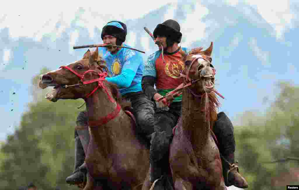 Horsemen play Kokpar, a traditional game between two teams competing to throw the dummy of a goat into a scoring circle, during the first Asian Equestrian Championship, near Almaty, Kazakhstan.