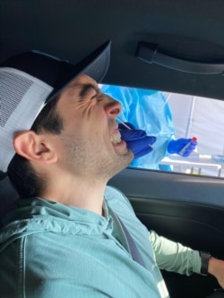 Casen Gavidia winces as he takes his coronavirus test at the drive-thru site.