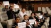 FILE - Yemeni journalists hold placards to support their colleagues jailed in Shi'ite Houthi rebel prisons in Yemen, during a press conference of the United Nations Special Envoy to Yemen in Kuwait City, May 5, 2016.