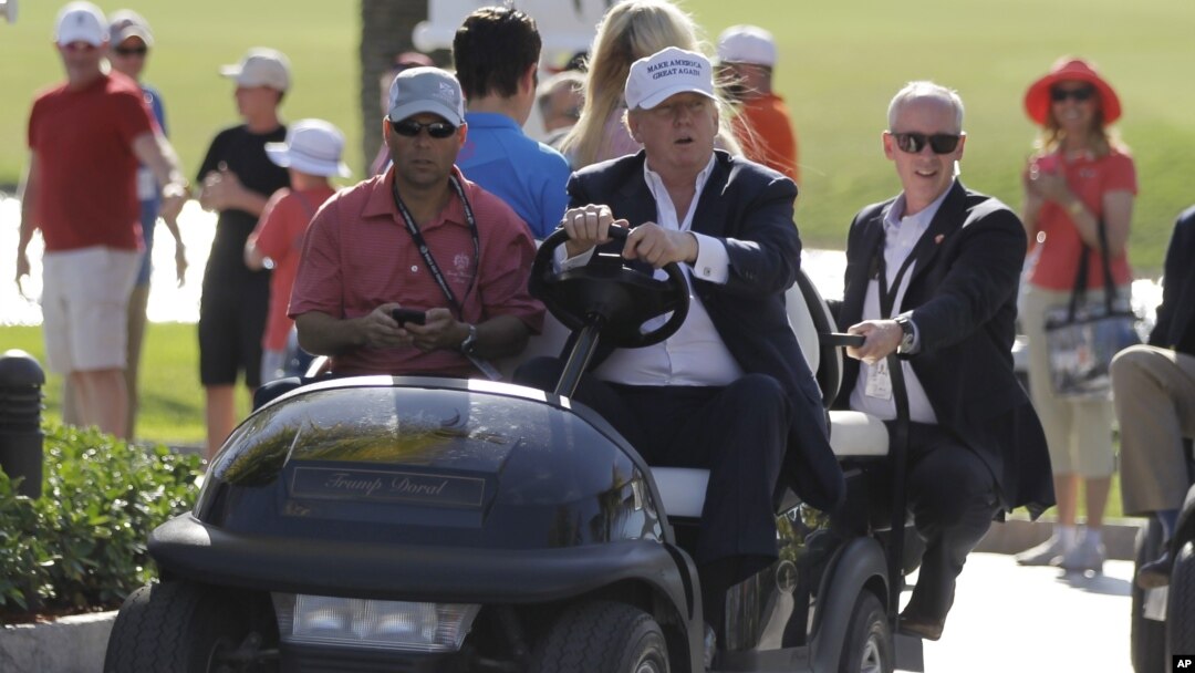 FILE - Donald Trump drives himself around a golf course in Doral, Florida.