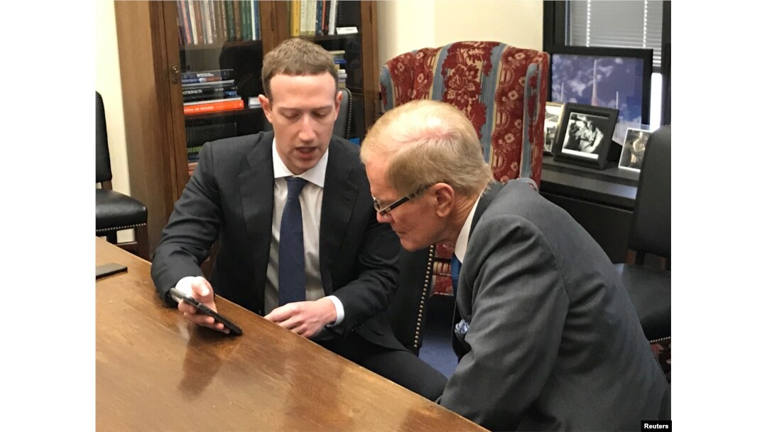 Facebook CEO Mark Zuckerberg holds a mobile phone while speaking with Senator Bill Nelson (D-FL) in the Hart Senate Office Building in Washington, April 9, 2018.