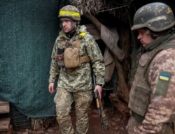 Ukrainian service members stand on the front line near the city of Novoluhanske in the Donetsk region on February 22, 2022.