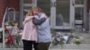 Leah Fauth gets a hug after leaving flowers in front of the West York Police Department after a police officer was killed responding to a shooting at UPMC Memorial Hospital in York, Pa., on Feb. 22, 2025. 