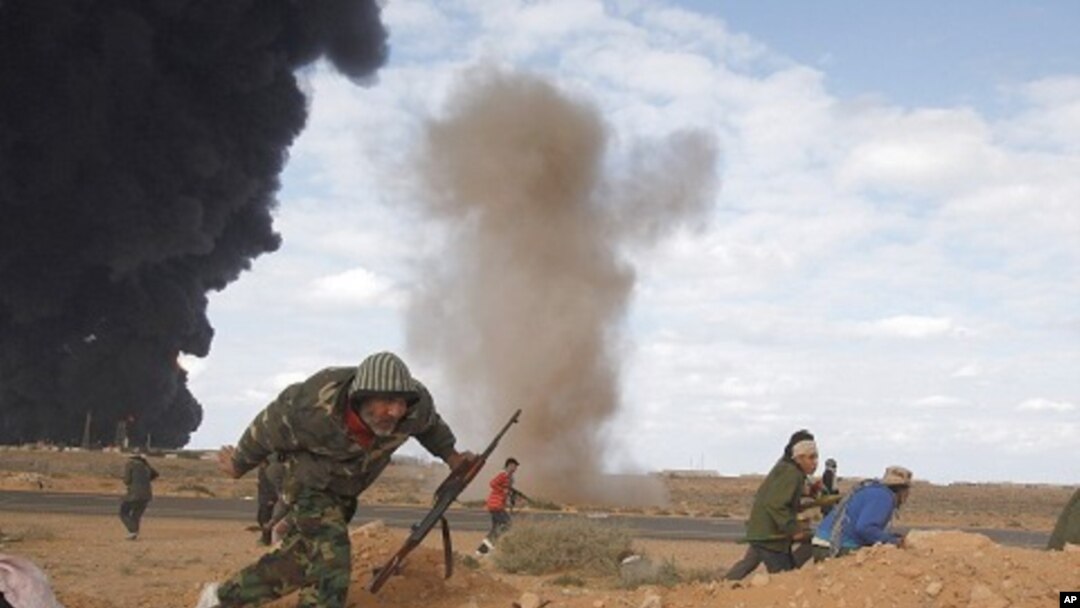 Rebels run for cover during clashes with pro-Gaddafi forces between Ras Lanuf and Ben Jawad, March 9, 2011