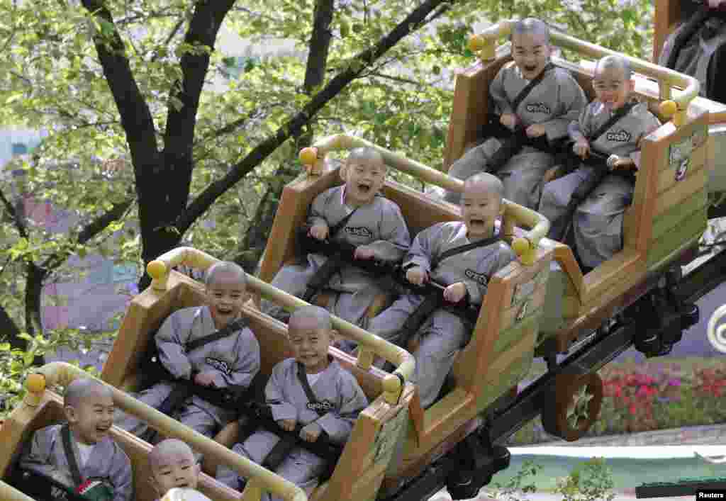 Child monks ride a roller coaster during their visit to the Everland amusement park in Yongin, South Korea.