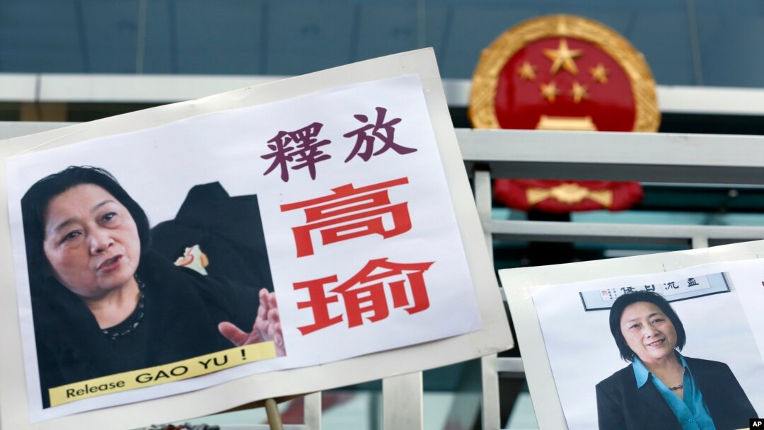 FILE - Pictures of jailed veteran Chinese journalist Gao Yu are displayed by protesters outside Chinese central government's liaison office in Hong Kong.