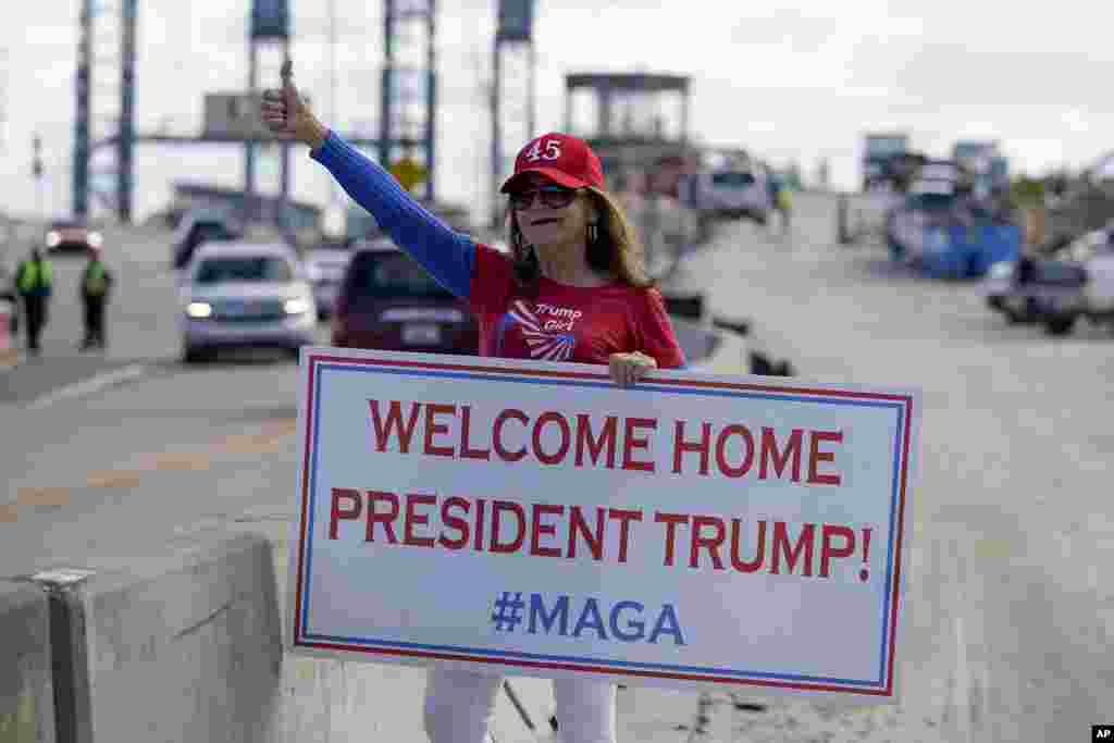 A supporter of President Donald Trump waits for the motorcade on the road to Mar-a-Lago, Trump's Palm Beach estate in West Palm Beach, Florida.
