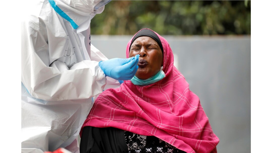 A woman reacts as a health worker takes a swab during coronavirus testing in the Kawangware neighborhood of Nairobi, Kenya, May 2, 2020.