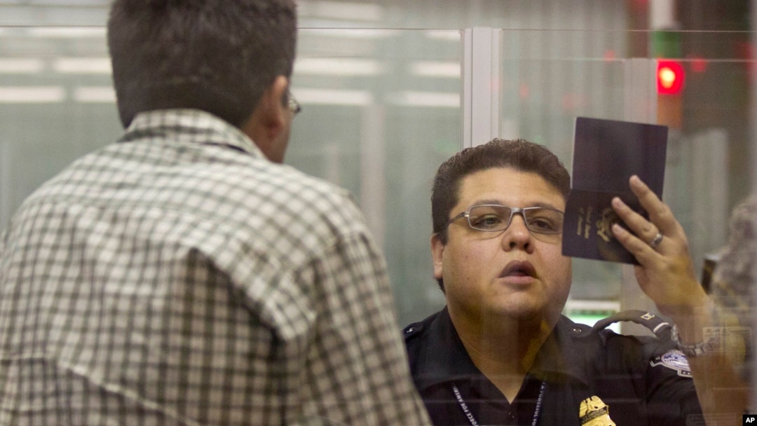 A Customs and Border Protection officer checks the passport of a non-resident visitor to the United States inside immigration control at McCarran International Airport, Tuesday, Dec. 13, 2011, in Las Vegas.